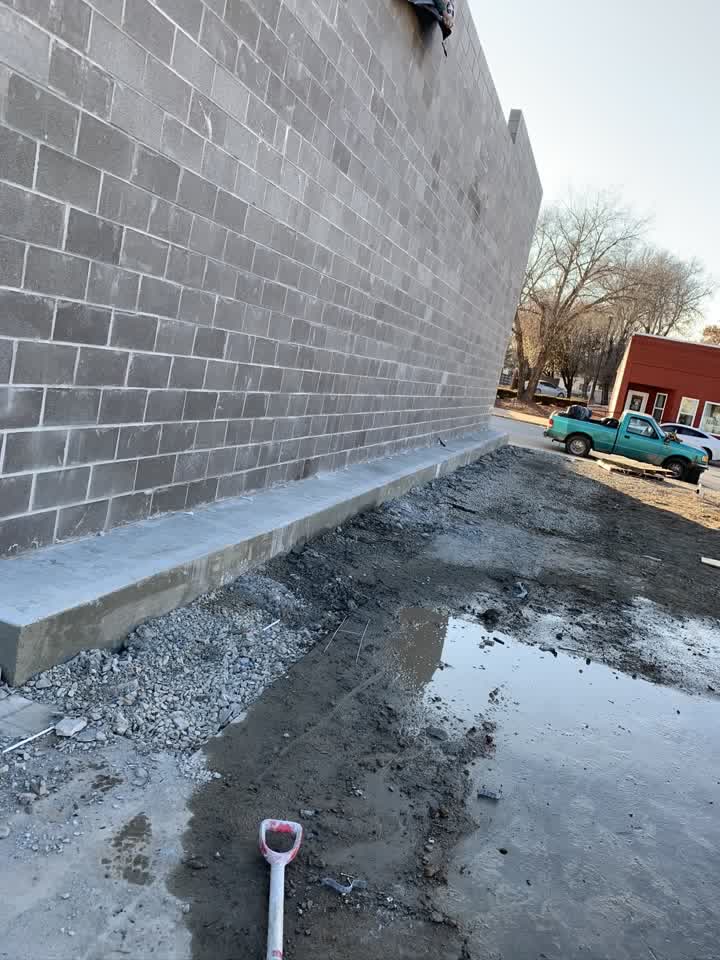Long block wall with new concrete base