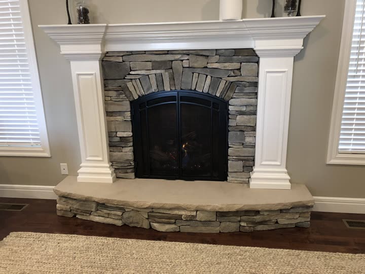 Finished natural stone fireplace with white mantel