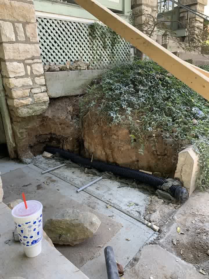 Drainage pipe installed behind the new stone wall