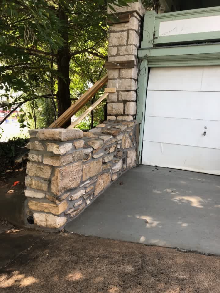 Finished stone wall beside a new concrete driveway