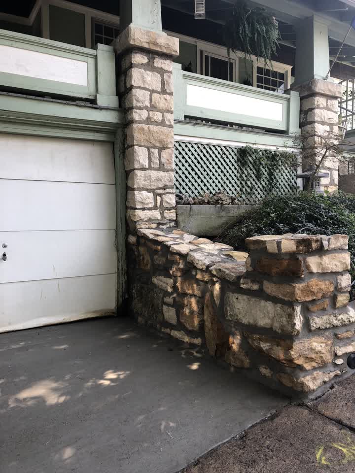 Natural stone wall beside the garage door