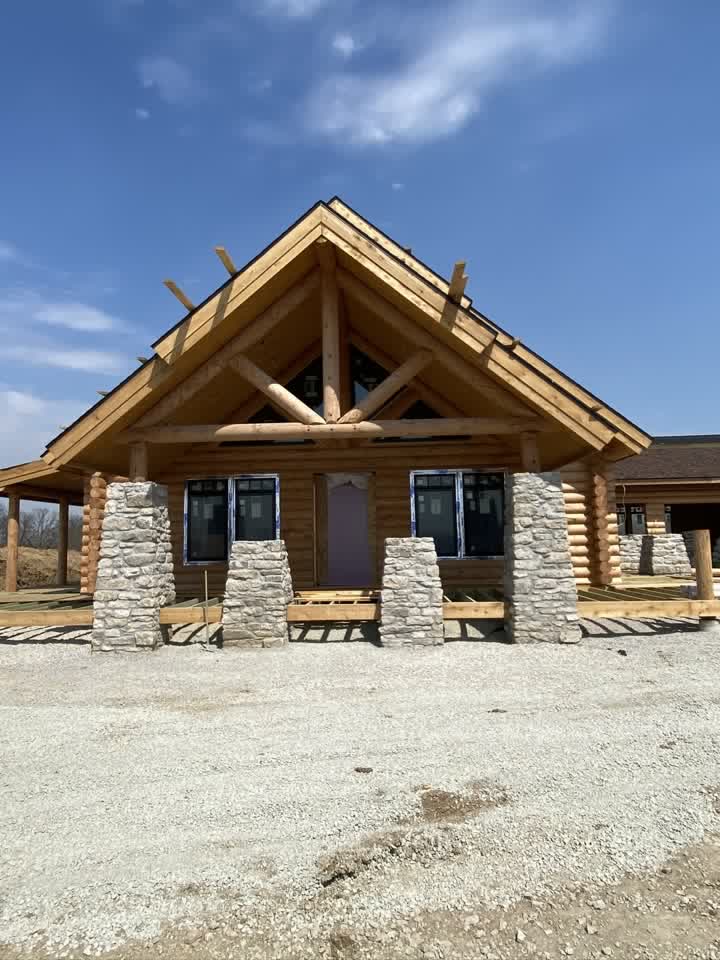 Log home front with finished stone pillars