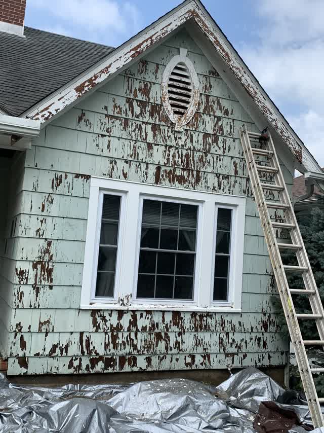 Gable end with peeling paint before prep