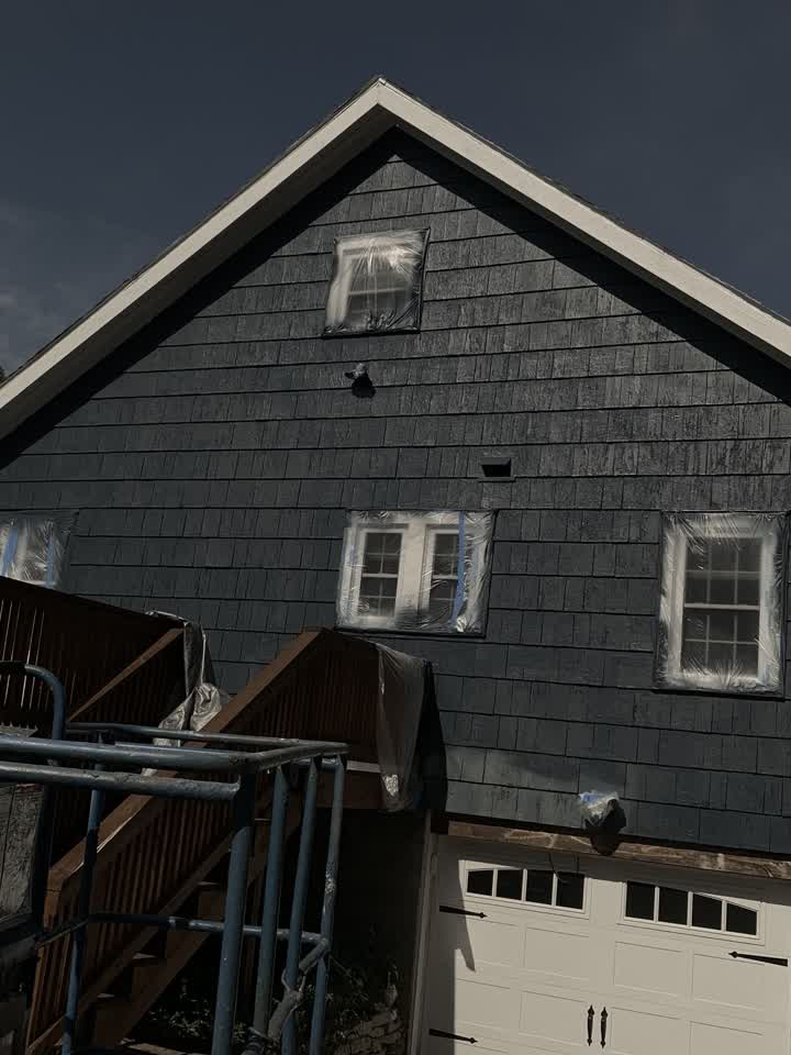 House masked with fresh dark paint going on