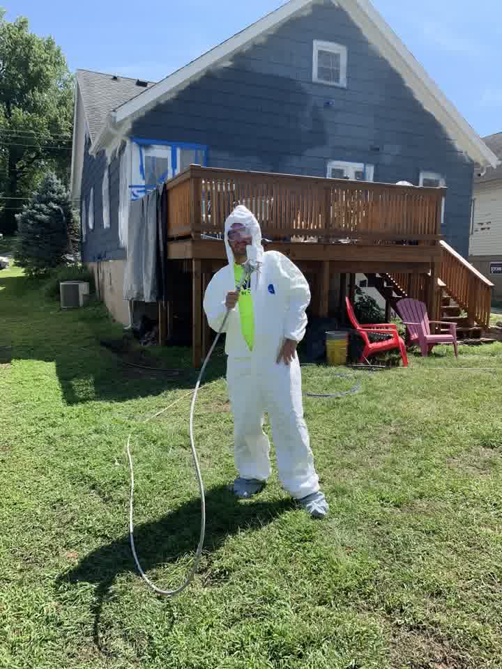 Painter spraying the house exterior