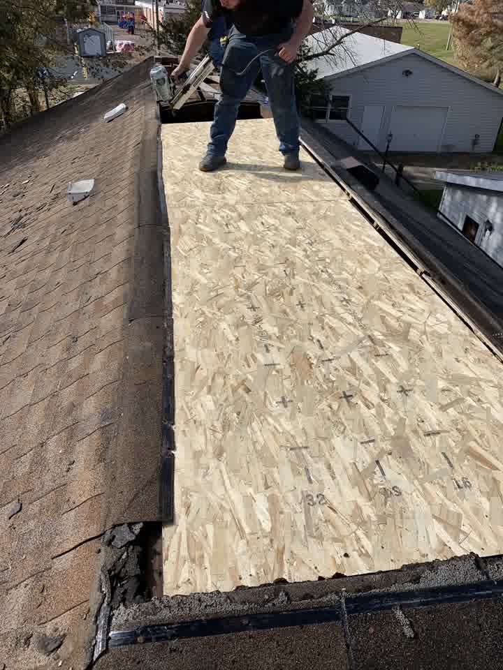 Worker nailing down new roof decking