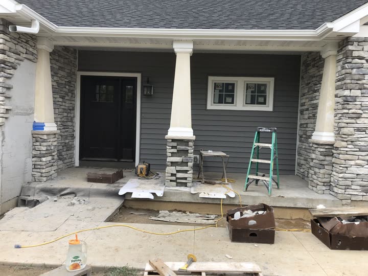 Stone veneer porch pillars being installed