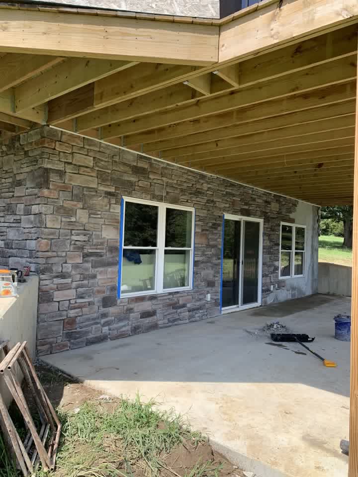 Stone veneer siding on the lower level with patio