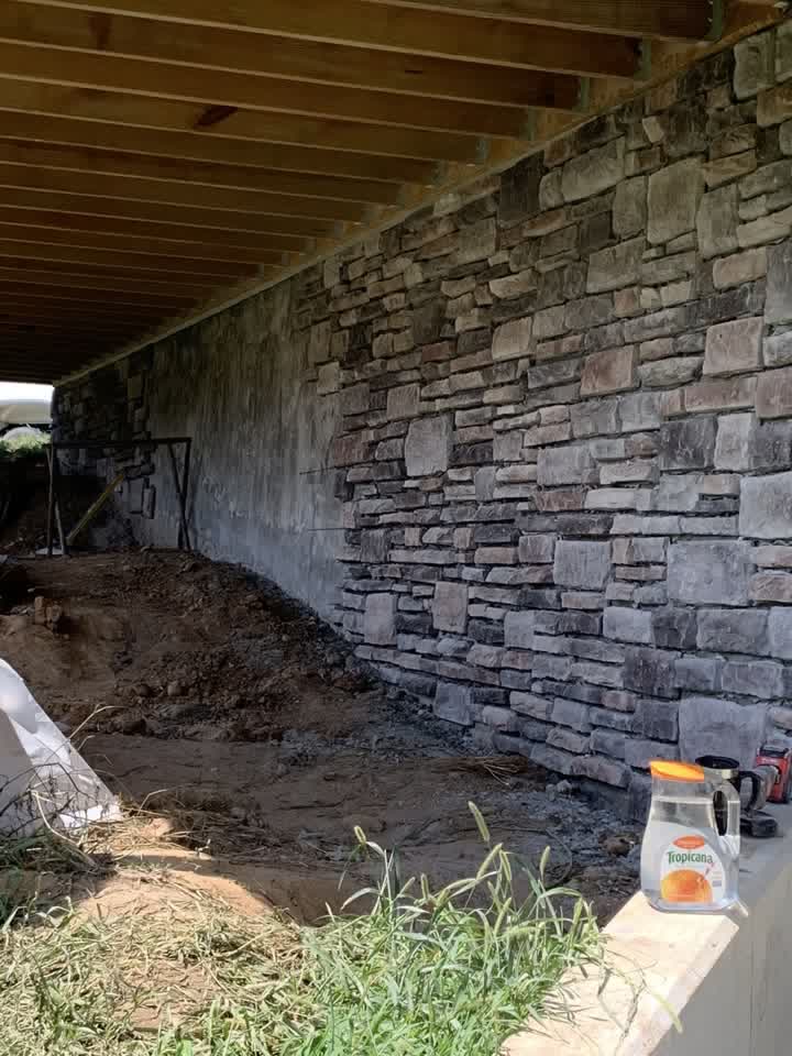 Stone veneer wall going up under the deck