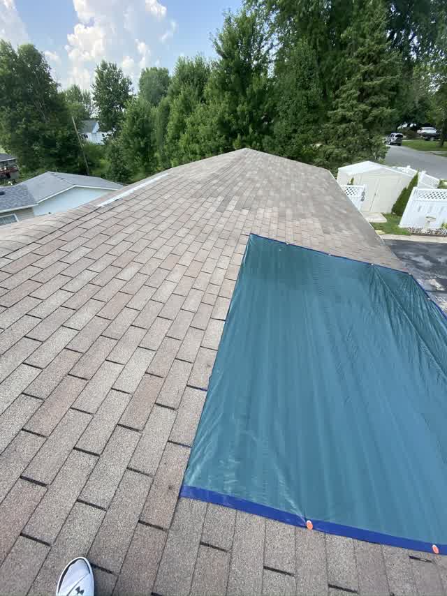Wide view of a tarped roof after storm damage